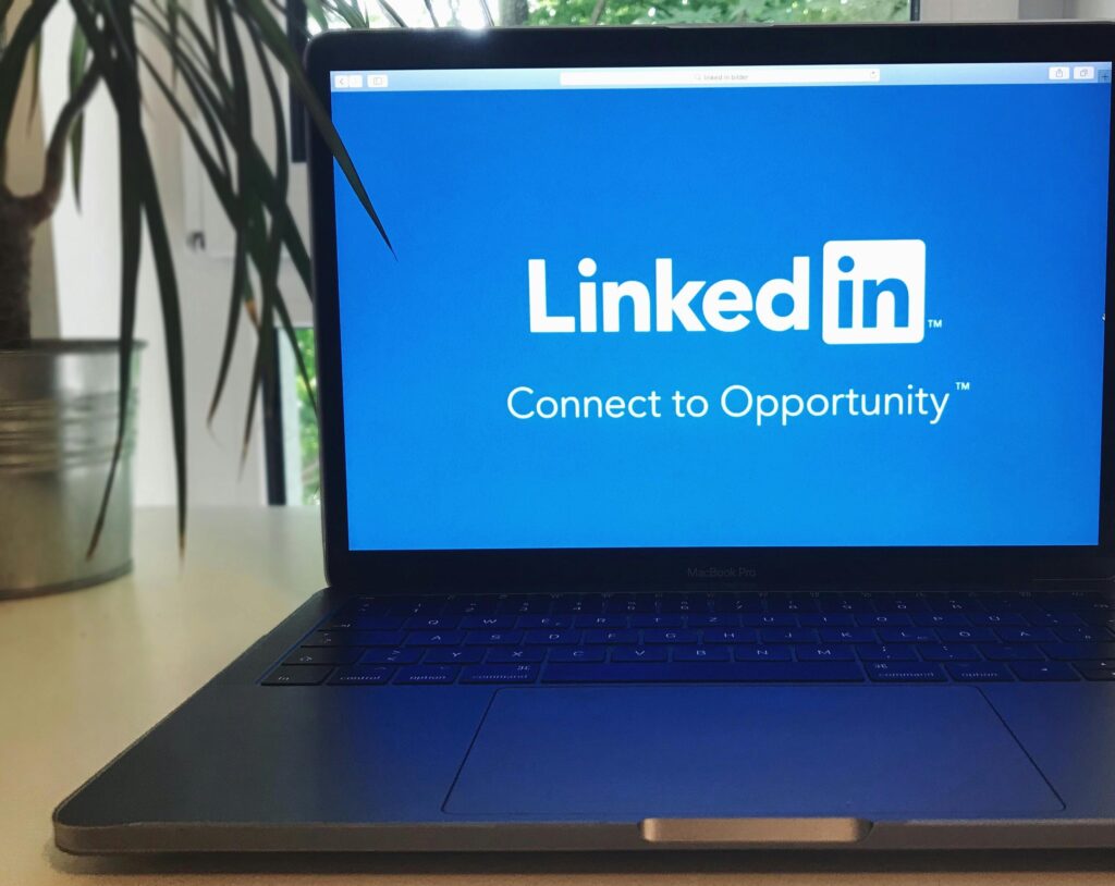 pexels-photo-1083792-1083792 A laptop screen displaying the LinkedIn logo with the text 'Connect to Opportunity'.